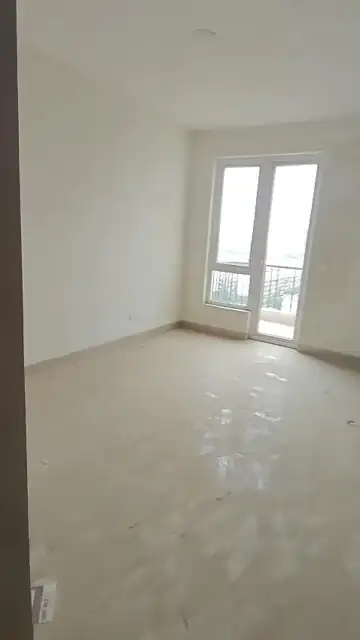 Living room with balcony access in the unused 3 BHK + 1 apartment for sale at Emaar Emerald Estate Sector 65 Gurgaon